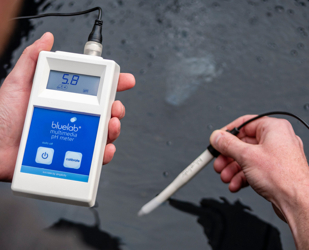 Handheld pH meter van Bluelab voor multimedia toepassingen, met een digitale display die een pH-waarde van 5.8 aangeeft. Het apparaat is ontworpen voor waterkwaliteitmetingen en is uitgerust met een gevoelsensor, die in het water is ondergedompeld. De meter heeft een automatische uitschakelfunctie en knoppen voor kalibratie. Dit product is ideaal voor zowel professioneel als hobbymatig gebruik in aquaponics, hydroponics en andere watergebaseerde systemen. Het meetinstrument is duurzaam ontworpen en draagt bij aan milieuvriendelijke waterbeheersing.